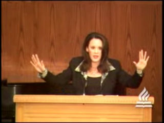 woman standing at podium speaking at DTS Chapel