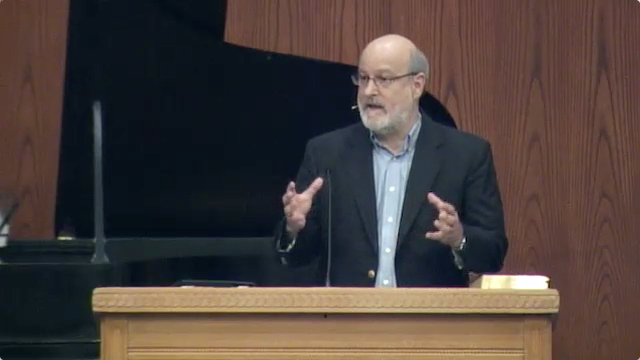 Dr. Darrell Bock standing at podium speaking at DTS Chapel