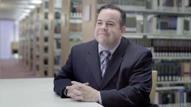 DTS alum Joe Parle seated at table in DTS library