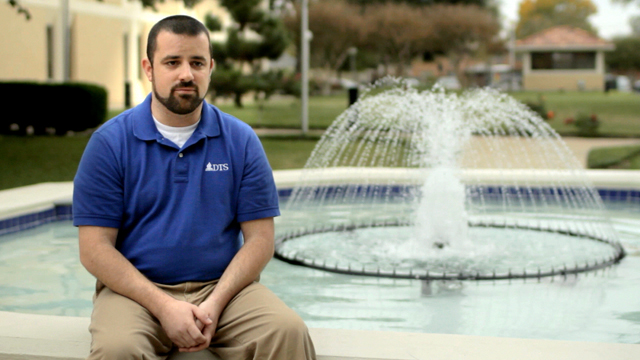 DTS alum Luke Perkins seated at fountain on DTS campus