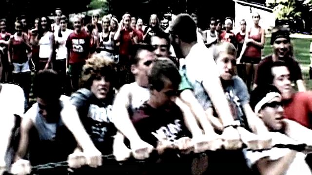 Young adults playing tug-of-war outdoors